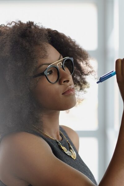 Friendly african american executive business woman brainstorming using green adhesive notes in a modern white office